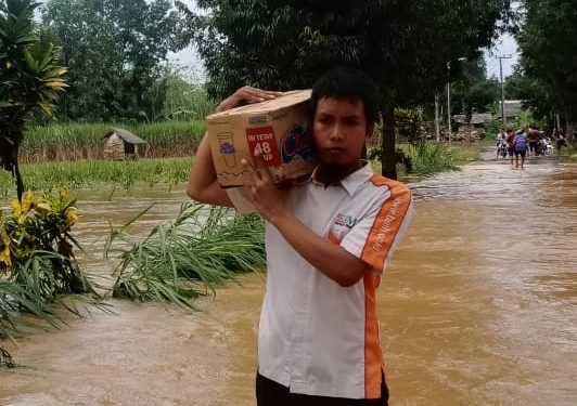 Relawan Terjang Banjir sambil Memikul Sembako untuk Bantuan