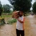 Relawan Terjang Banjir sambil Memikul Sembako untuk Bantuan
